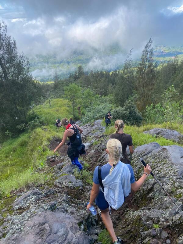 Group Of Hikers Descending Rocky Mountain Trail Foggy Weather