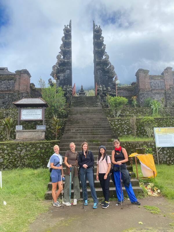 Group Of Hikers Five People Trekking Sticks Balinese Temple Background