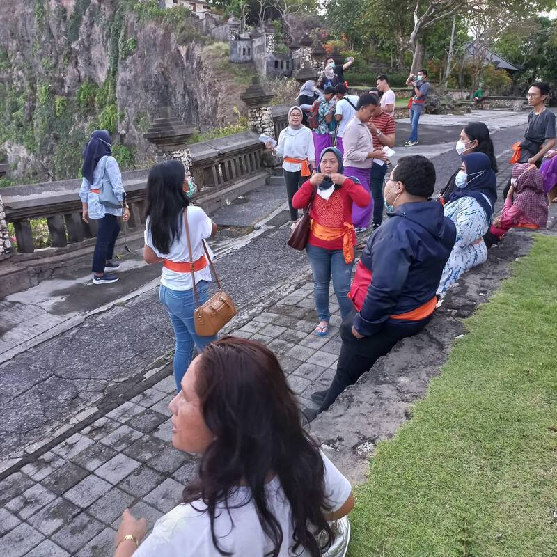Group Of People Tourists Wearing Orange Sashes Near Cliffside Path