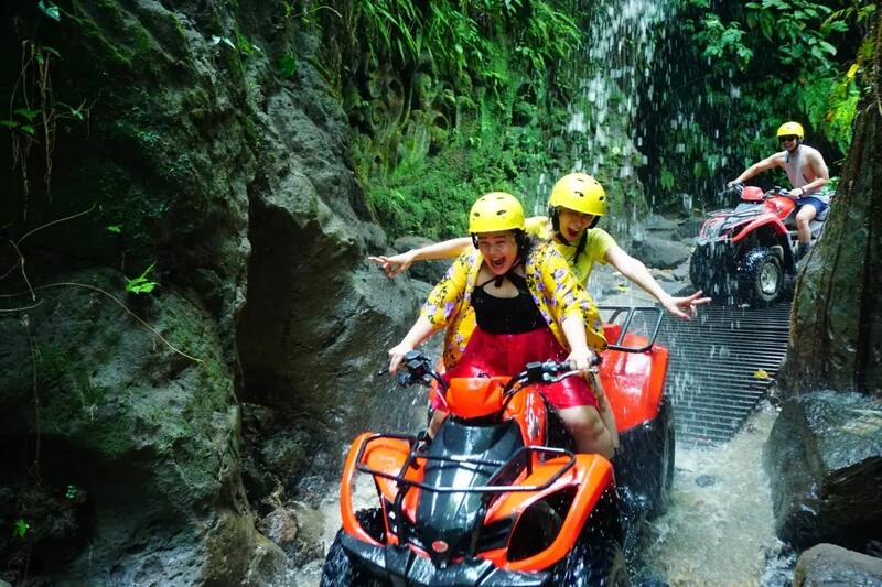 People Enjoying Atv Ride Under Waterfall In Forest