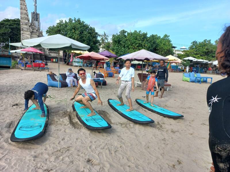 People Learning Surfing On Surfboards On Sandy Beach