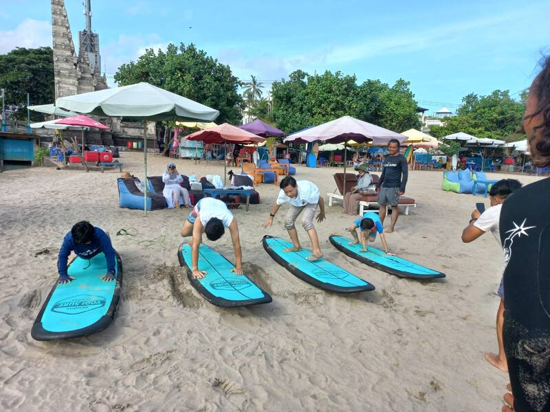 People Practicing Surfing On Sand Surfboard Training Beach