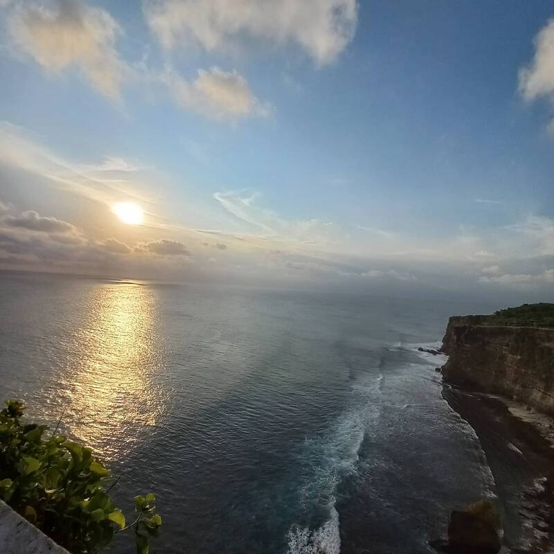 Sunset Over Ocean With Cliff And Cloudy Sky Reflection