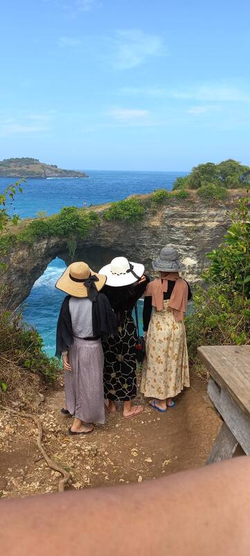 Three Women In Hats Standing Clifftop Ocean View Nature