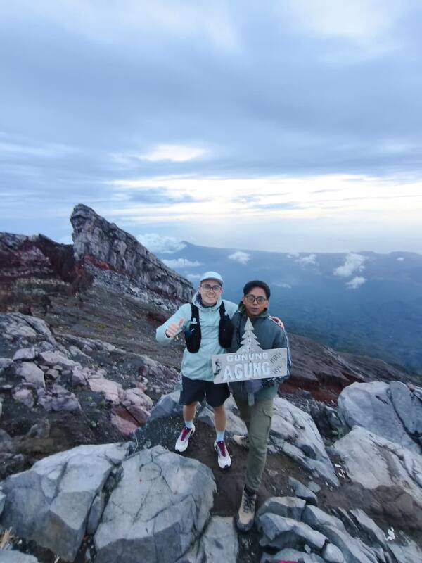 Two Men Hiking Mountain Summit Gunung Agung Sign Cloudy Sky
