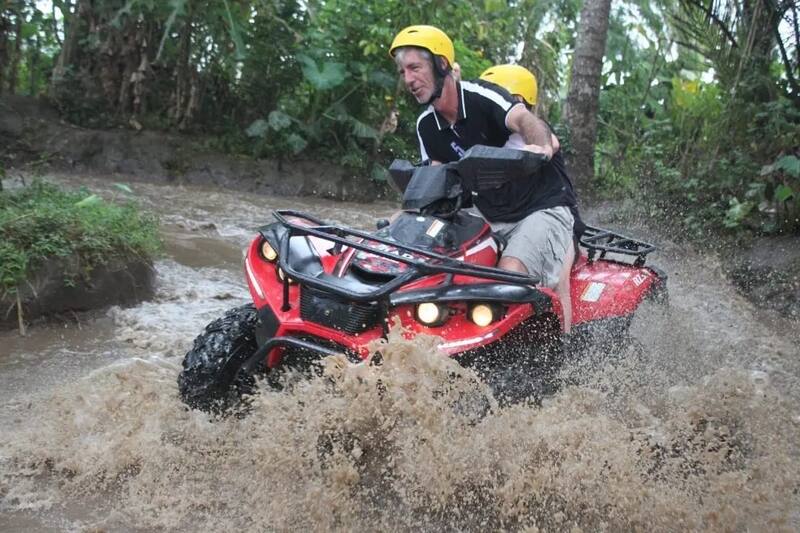 Two Men Riding Red Atv Through Water Puddle Offroad Adventure