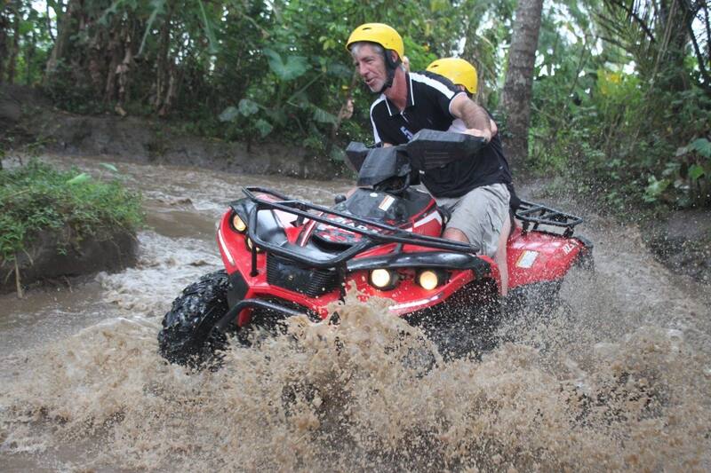 Two People Riding Red Atv Through Muddy Waterforest