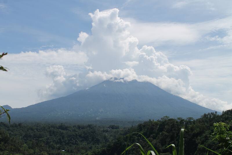 Volcanic Mountain With Thick Clouds Above Forest Landscape